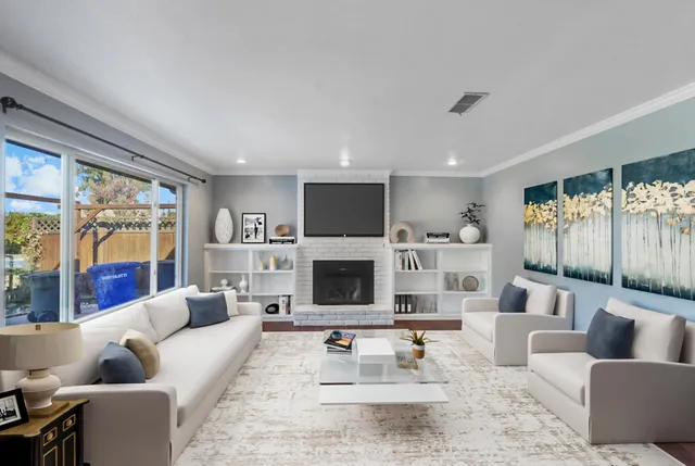 a living room with furniture a fireplace and a large window