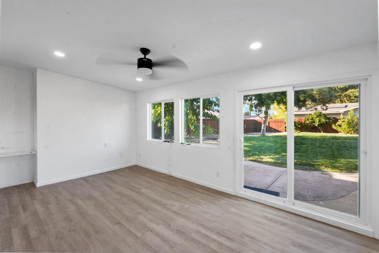 728 R Street Newman, CA 95360 - Photo 12 of 19 a view of an empty room with wooden floor and a window