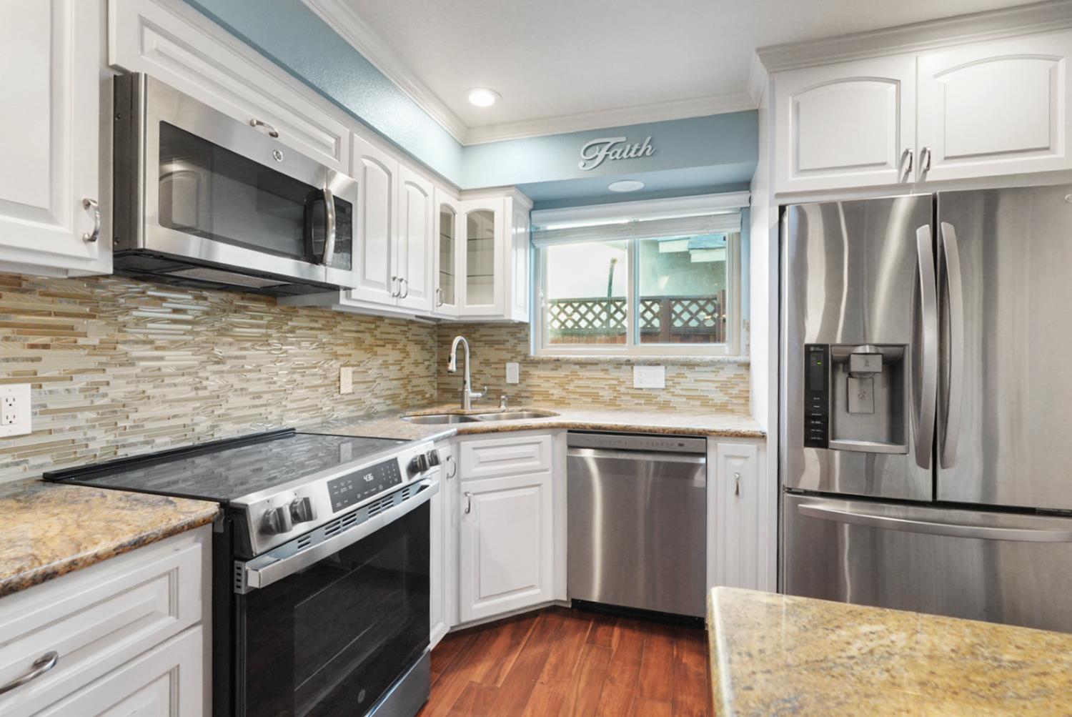 728 R Street Newman, CA 95360 - Photo 3 of 19 a kitchen with stainless steel appliances granite countertop a stove top oven microwave and refrigerator