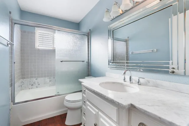 a bathroom with a granite countertop sink toilet and shower