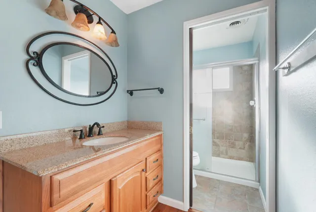 a bathroom with a sink a toilet and a mirror