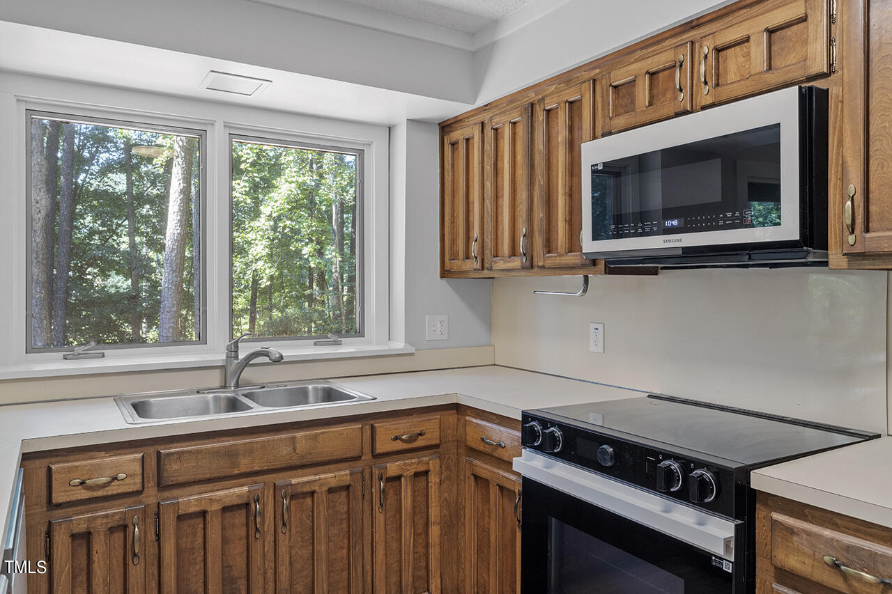 705 Lanham Place Raleigh, NC 27615 - Photo 14 of 53 a kitchen with a stove a sink and a window