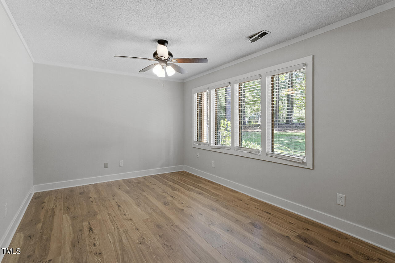 705 Lanham Place Raleigh, NC 27615 - Photo 23 of 53 a view of empty room with wooden floor and fan