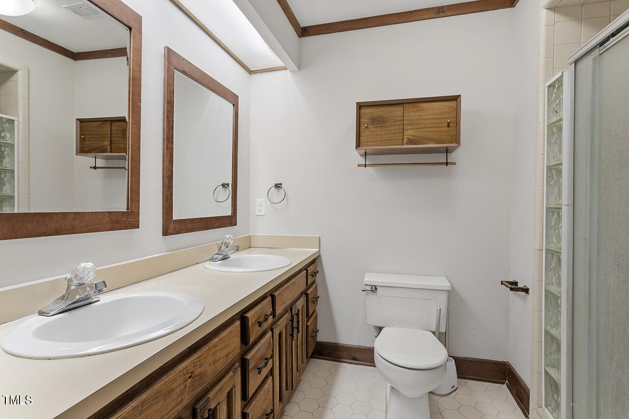 705 Lanham Place Raleigh, NC 27615 - Photo 33 of 53 a bathroom with a granite countertop toilet sink and mirror