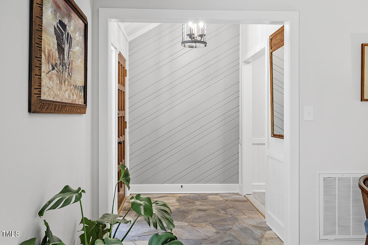 705 Lanham Place Raleigh, NC 27615 - Photo 5 of 53 a view of a hallway with wooden floor and a potted plant