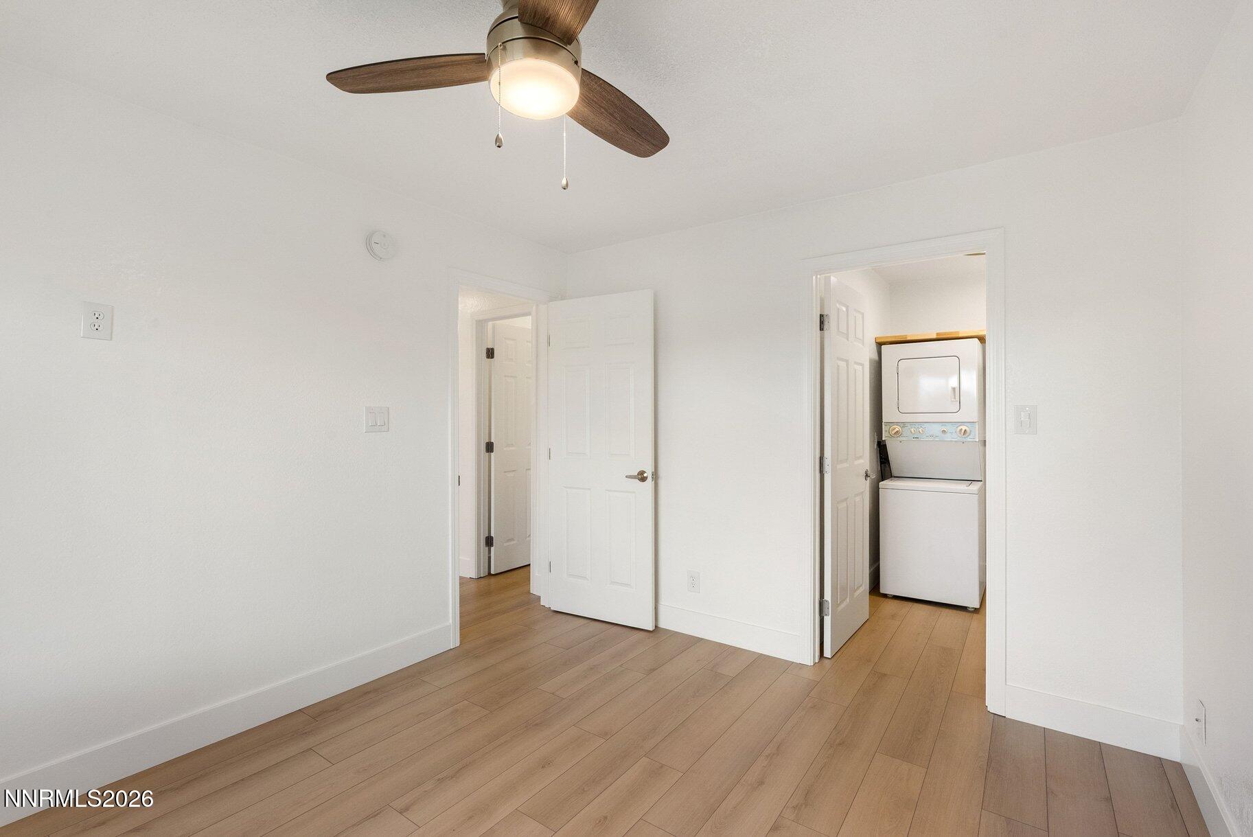 3935 Clear Acre Lane, Unit 211 Reno, NV 89512 - Photo 9 of 25 an empty room with wooden floor cabinet and windows