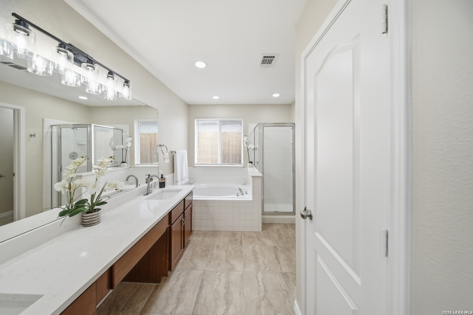 5607 Spring Quail San Antonio, TX 78247 - Photo 15 of 25 a spacious bathroom with a double vanity sink a mirror and a bathtub