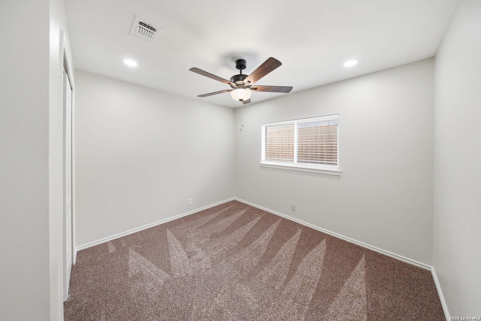 5607 Spring Quail San Antonio, TX 78247 - Photo 19 of 25 an empty room with a window and a ceiling fan