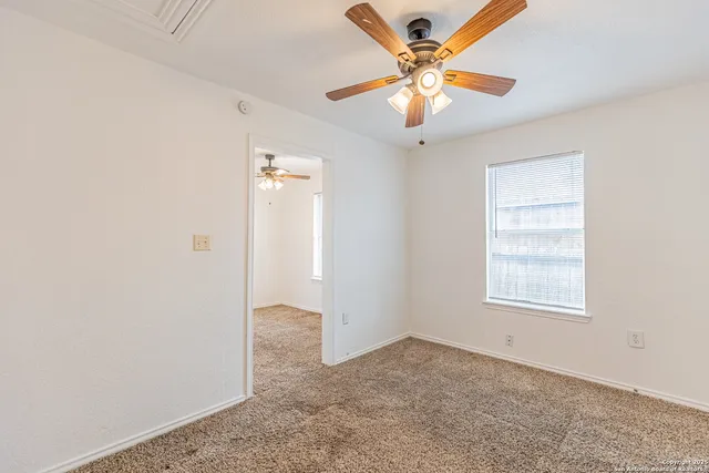 an empty room with closet and a chandelier fan