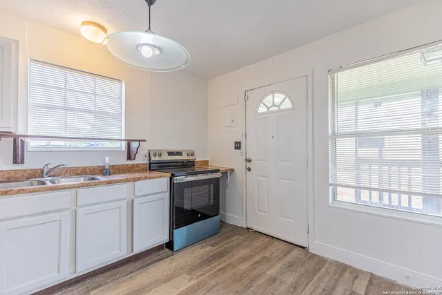 a view of a kitchen with stove and sink