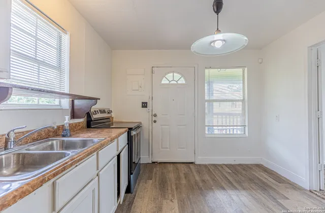 a kitchen that has a sink stove and cabinets
