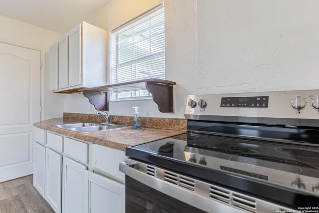 a kitchen with a stove and white cabinets