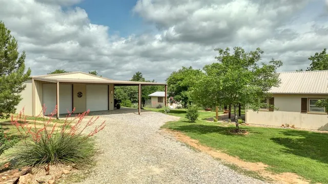 a front view of a house with a garden and trees
