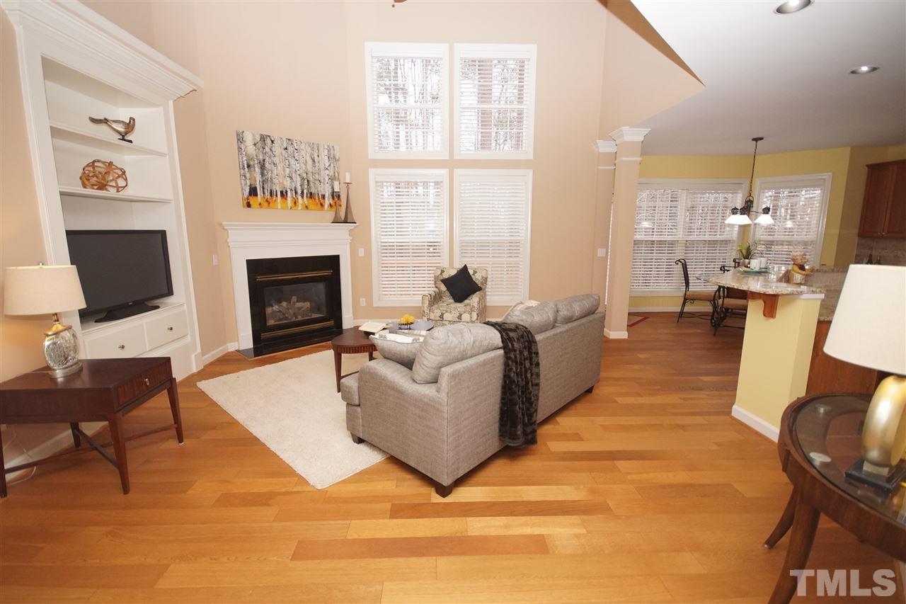 12520 Amoretto Way Raleigh, NC 27613 - Photo 11 of 25 a living room with furniture a fireplace and a flat screen tv