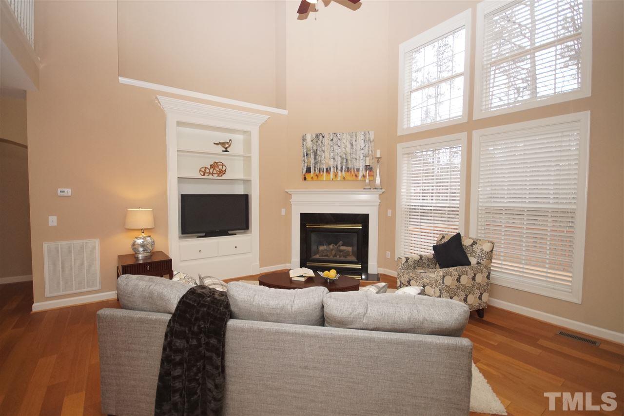 12520 Amoretto Way Raleigh, NC 27613 - Photo 12 of 25 a living room with furniture a flat screen tv and a fireplace
