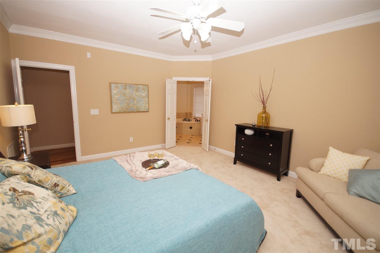 12520 Amoretto Way Raleigh, NC 27613 - Photo 15 of 25 a bedroom with a bed and a chandelier
