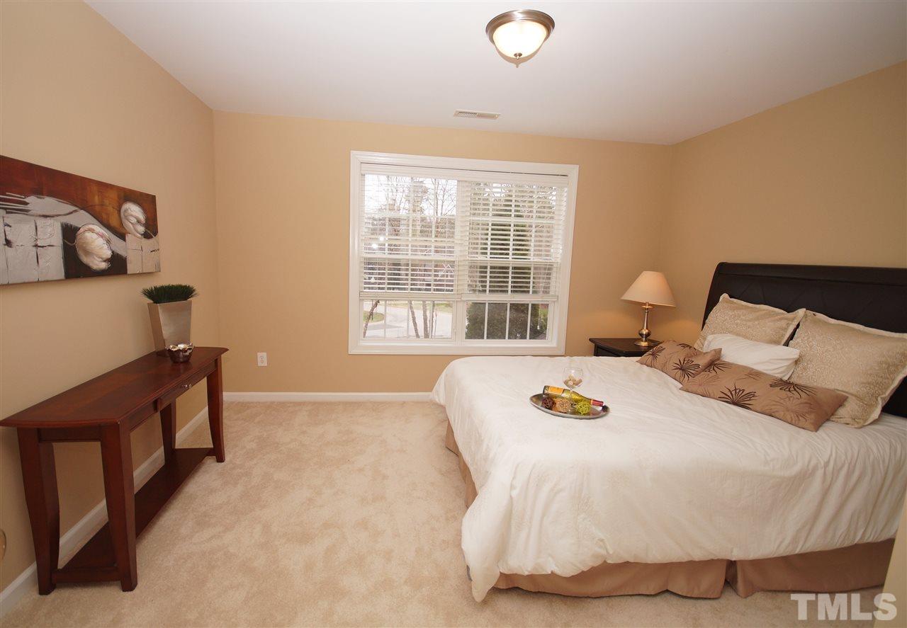 12520 Amoretto Way Raleigh, NC 27613 - Photo 18 of 25 a bedroom with a bed and wooden floor