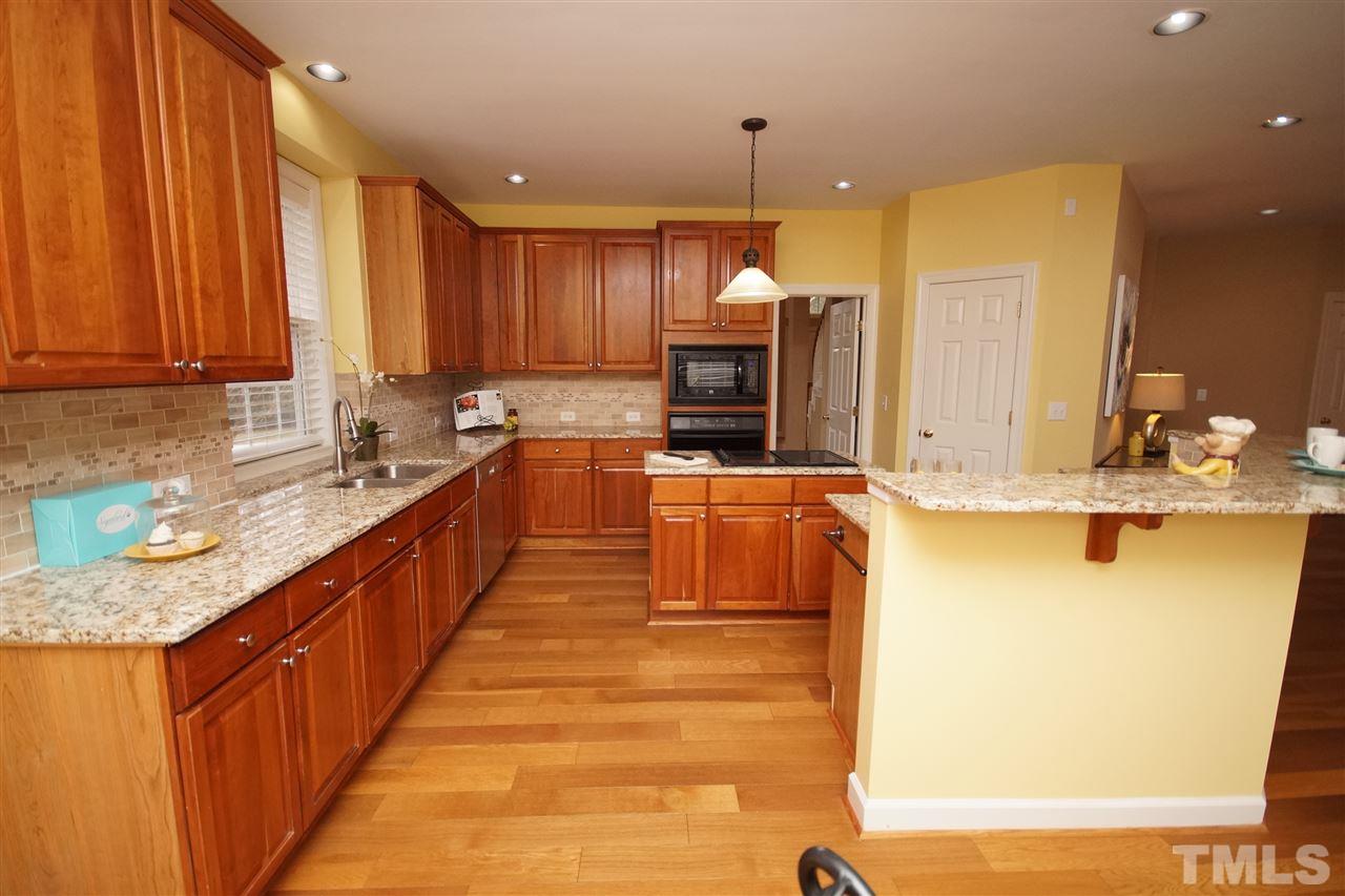 12520 Amoretto Way Raleigh, NC 27613 - Photo 7 of 25 a kitchen with kitchen island granite countertop a sink and counter top