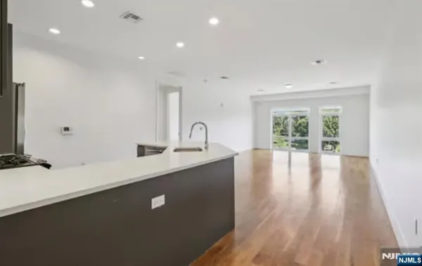 a view of a sink and dishwasher with wooden floor