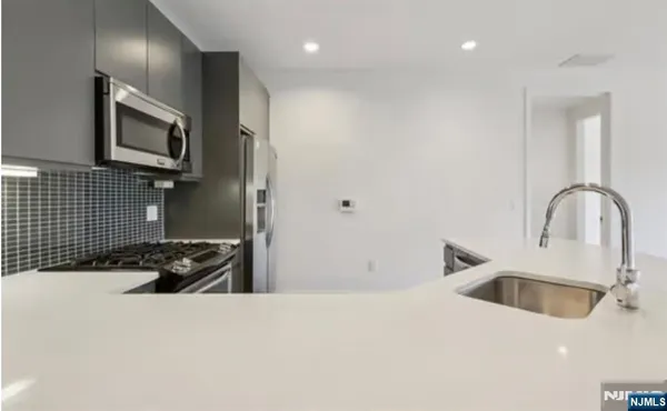 a kitchen with a sink and a stove top oven with wooden floor