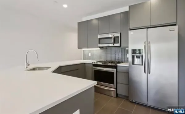 a kitchen with stainless steel appliances a refrigerator sink and stove