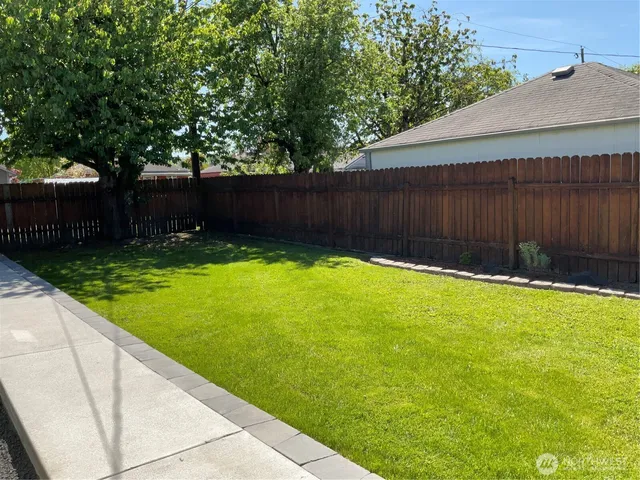 a view of a backyard with a small cabin and wooden fence