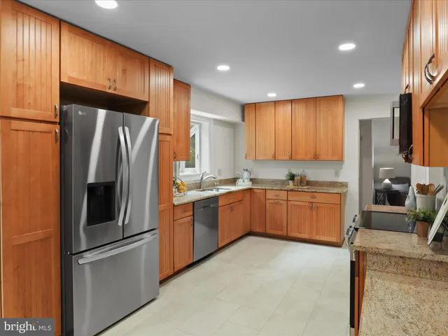 a kitchen with stainless steel appliances granite countertop a refrigerator stove and sink