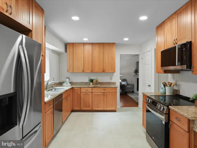 a kitchen with stainless steel appliances granite countertop a refrigerator stove and sink