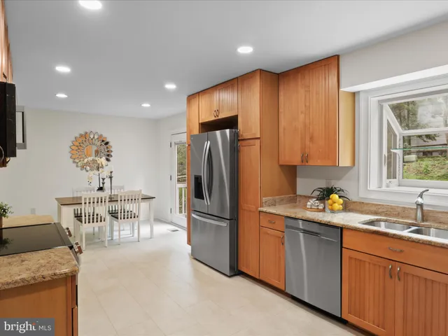 a kitchen with stainless steel appliances granite countertop a refrigerator and a sink