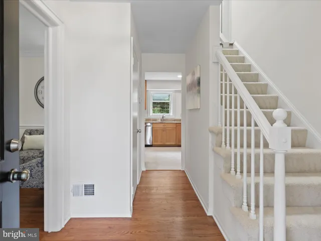 a view of a hallway with wooden floor and entryway