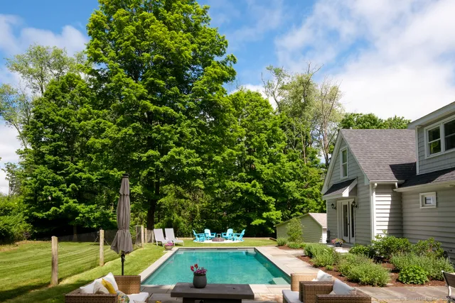 a view of a house with backyard sitting area and swimming pool