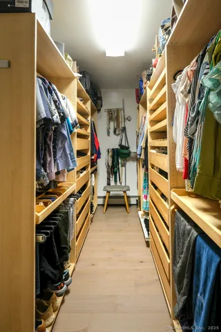 a view of walk in closet with clothes and shoes