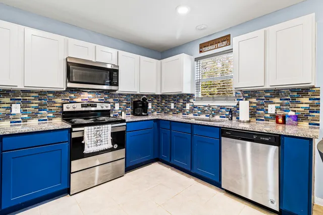 a kitchen with stainless steel appliances granite countertop a stove a sink dishwasher and a microwave oven on the kitchen countertops