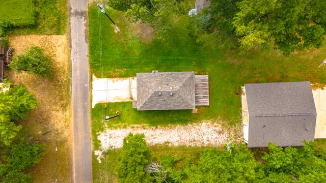 an aerial view of a residential houses with yard