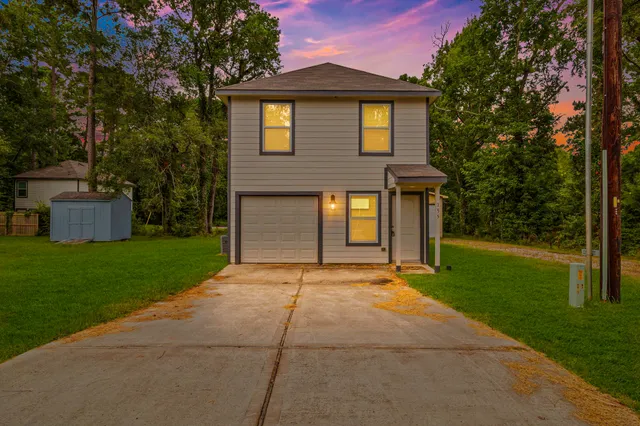a front view of a house with a yard and trees