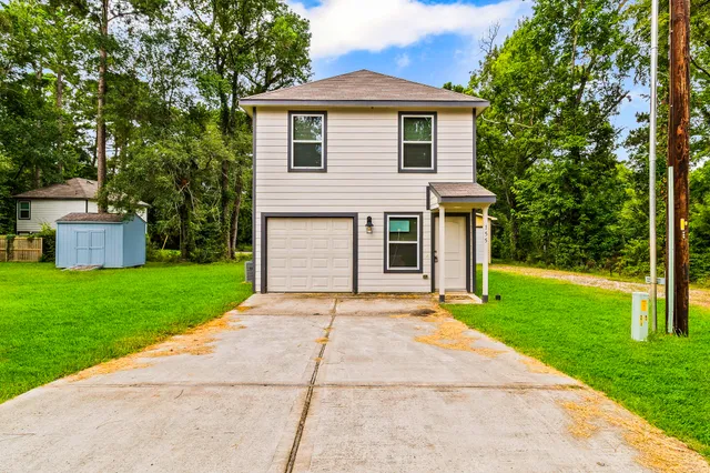 a front view of a house with a yard and a garage