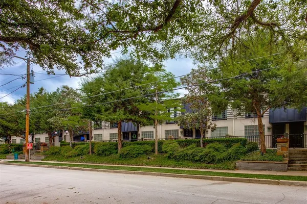 a front view of a house with a yard and an trees