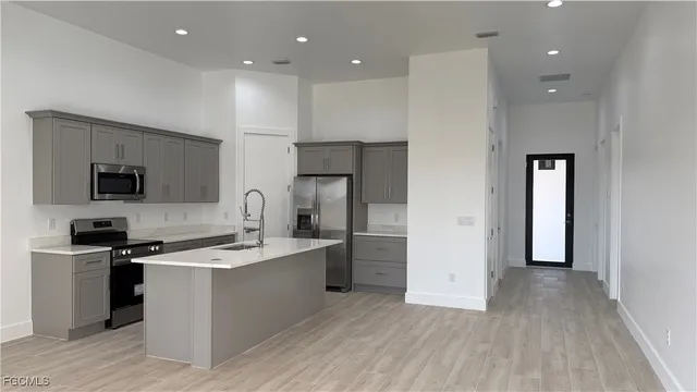 a kitchen with stainless steel appliances granite countertop a sink stove and refrigerator