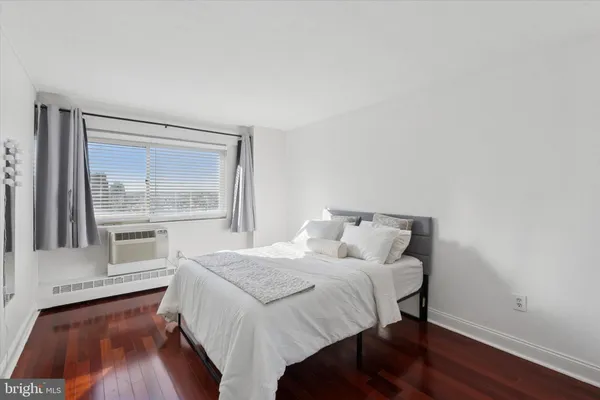 a bedroom with a bed and a large window