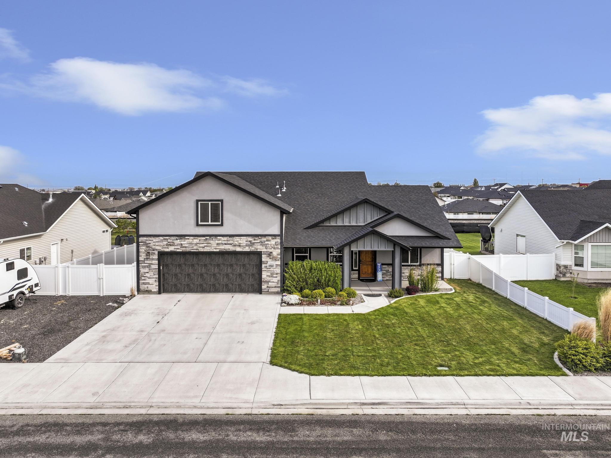 1150 Kimberly Meadows Road Kimberly, ID 83341 - Photo 2 of 32 Modern home exterior with a stone veneer accent, attached two-car garage, and a covered entry