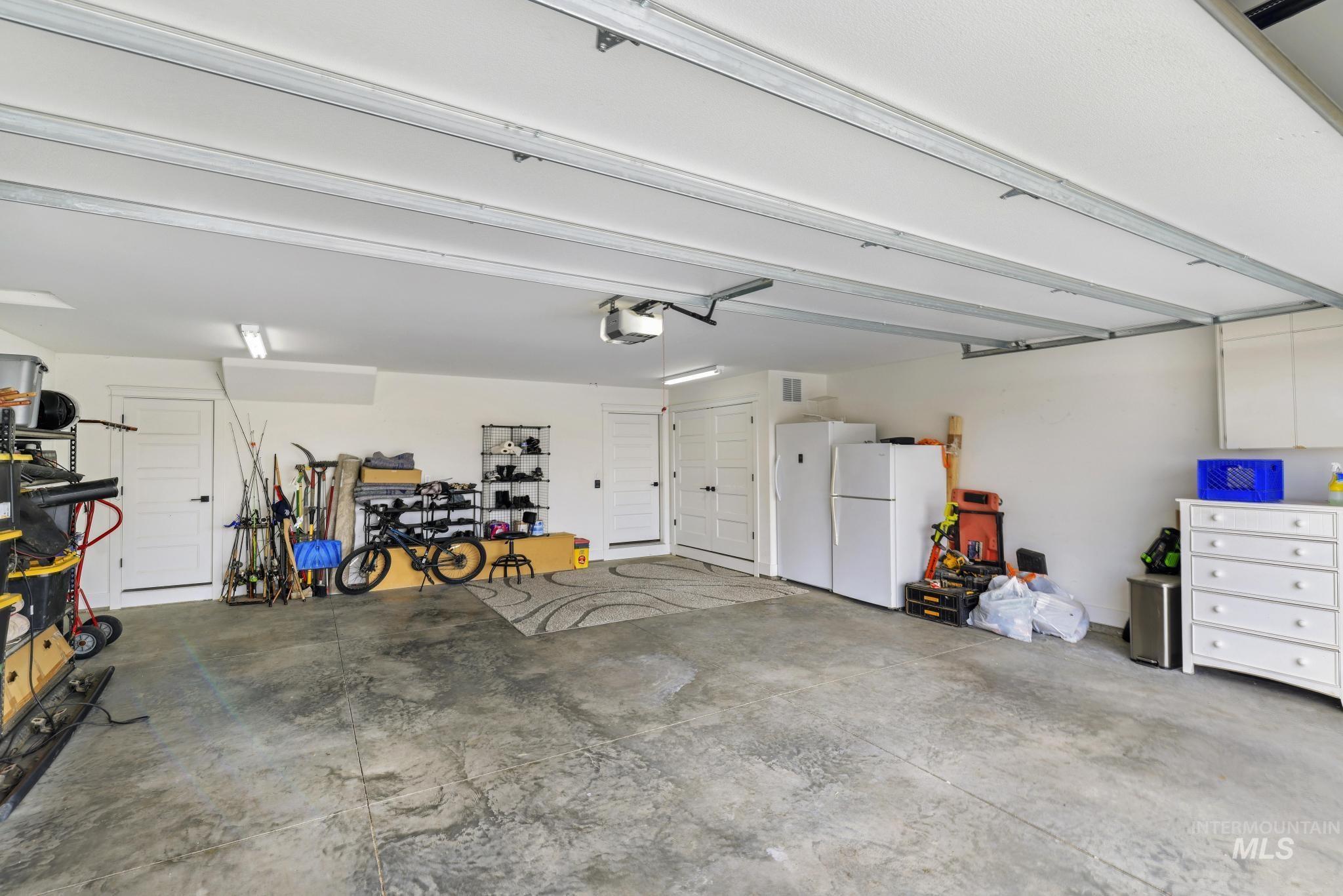 1150 Kimberly Meadows Road Kimberly, ID 83341 - Photo 23 of 32 Spacious garage featuring a concrete floor, bright overhead lighting, and white panel doors