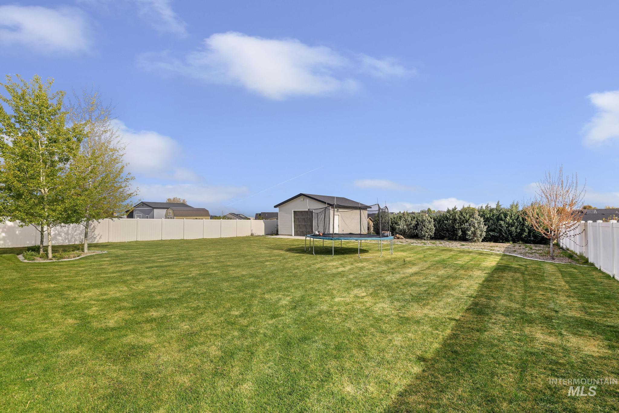1150 Kimberly Meadows Road Kimberly, ID 83341 - Photo 26 of 32 Spacious backyard featuring an expansive lawn area and white privacy fencing