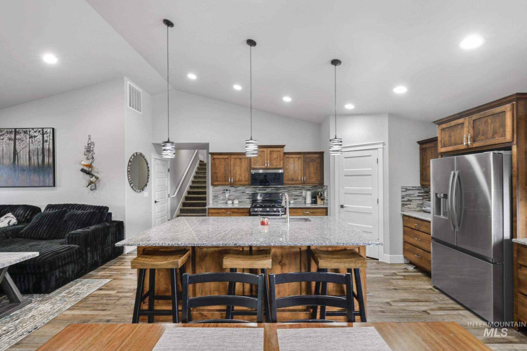 1150 Kimberly Meadows Road Kimberly, ID 83341 - Photo 5 of 32 Spacious open-concept kitchen featuring a large island with a stone countertop, rich wood cabinetry, stainless steel appliances, and wood-finish flooring