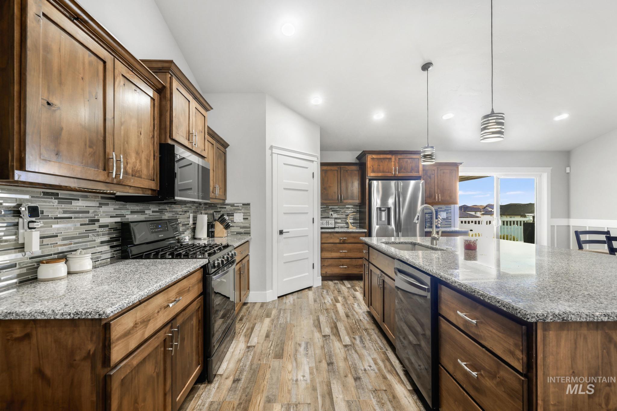 1150 Kimberly Meadows Road Kimberly, ID 83341 - Photo 7 of 32 Kitchen featuring wood-finish cabinetry, granite countertops, stainless steel appliances, and wood-finish flooring