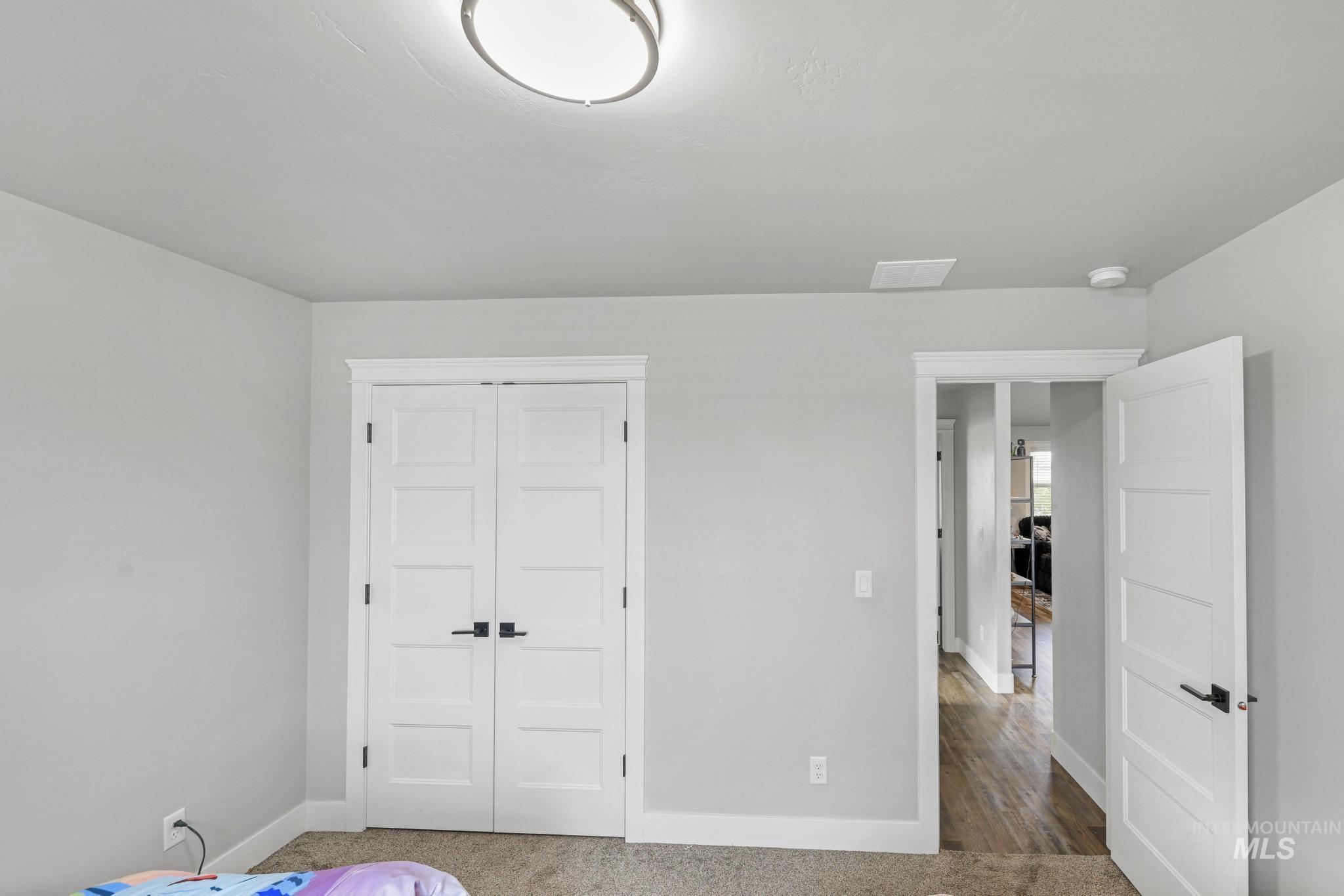 1150 Kimberly Meadows Road Kimberly, ID 83341 - Photo 9 of 32 Bedroom featuring a modern flush-mount ceiling light, light gray painted walls, and neutral carpet flooring