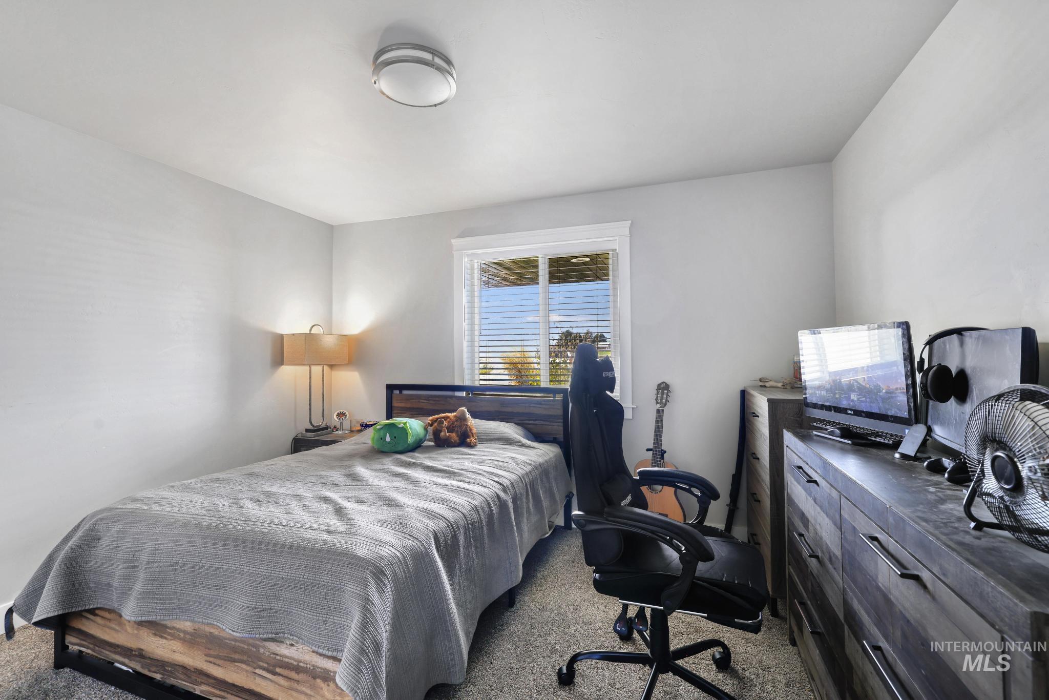 1150 Kimberly Meadows Road Kimberly, ID 83341 - Photo 10 of 32 Carpeted bedroom featuring a window with blinds, a ceiling-mounted light fixture, and light gray wall paint