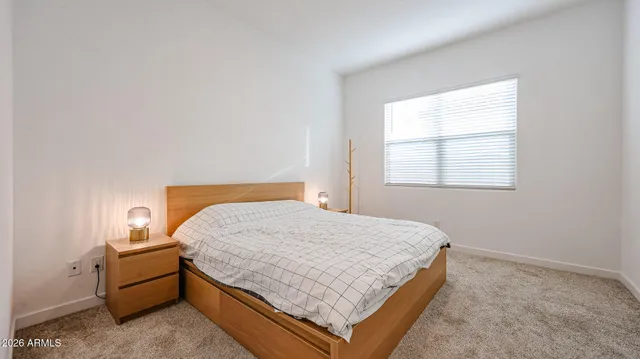 a bed sitting in a bedroom next to a window