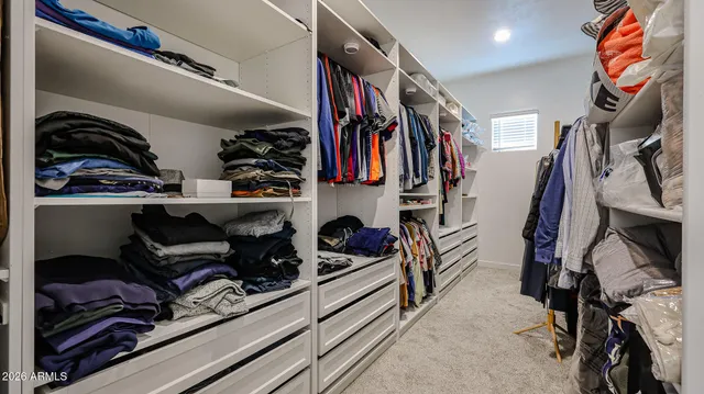 a bedroom with a bed and a flat tv screen on dresser