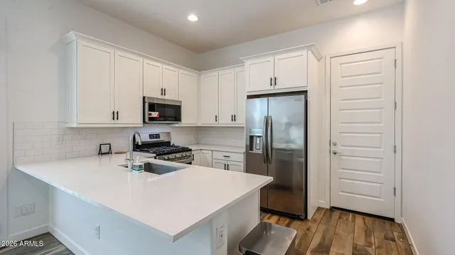 a kitchen with a refrigerator a stove and white cabinets