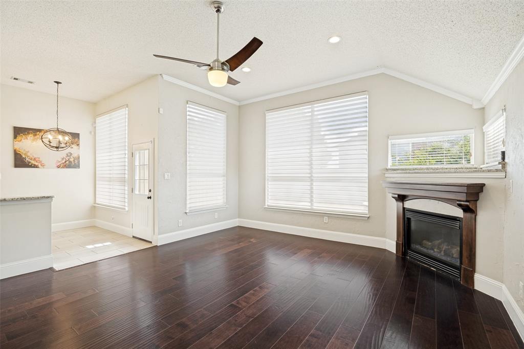 2100 Los Rios Boulevard Plano, TX 75074 - Photo 8 of 25 Spacious living area featuring dark wood-finish flooring, a contemporary ceiling fan, and abundant natural light from multiple large windows